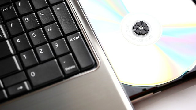 Male hand inserting/ejecting a disc from a laptop