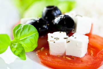 Closeup of tomato salad with goat cheese and olives