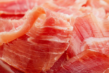 Spanish Serrano Ham Jamon sliced closeup background