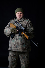 Portrait of a man with a gun on a black.