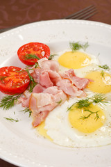 fried eggs with bacon and vegetables