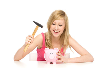 Young woman breaking piggy bank