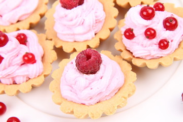 Obraz na płótnie Canvas Tartlets with whipped cream and raspberries or redcurrants