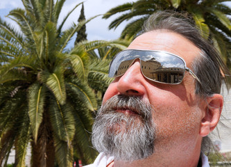 Tourist on a background of palm trees in glasses