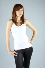 The young long-haired girl in a white vest on a grey background