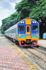 Fototapeta premium Tajski kolorowy pociąg przybywający do stacji
