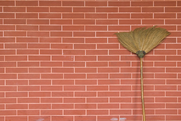 broom on brick wall