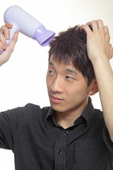 Concept image of metrosexual male featuring a young male using a