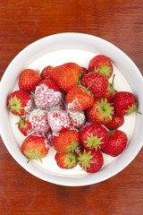 A bowl of strawberries and cream.