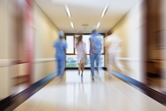 Surgeon And Nurse Running In Passageway