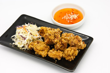 fried chicken in black plate with sauce