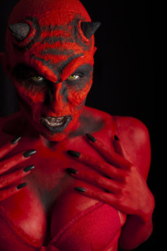 Sexy red devil woman. Dark background.