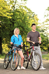 Plakat Happy smiling couple with bikes posing