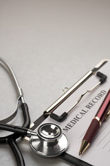 Doctor's stethoscope and patient's medical record on clip board