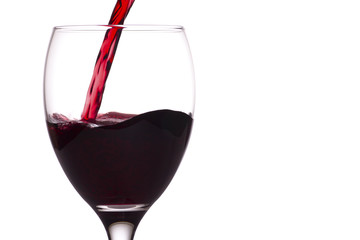 Red wine being poured into a glass, white background.