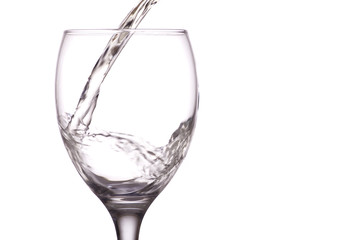 White wine being poured into a glass, white background.