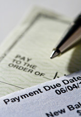 Personal check and credit card statement with pen