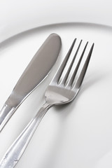 Silver fork and knife on white plate