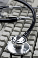 Doctor's stethoscope on computer keyboard