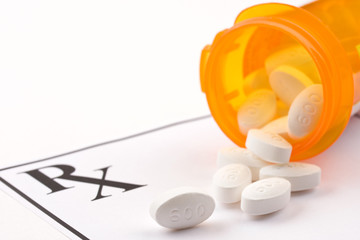 Medicine bottle and pills on doctor's prescription