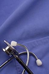 Doctor's stethoscope laying on scrubs.