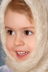 Portrait of the little girl. The cheerful girl in scarf