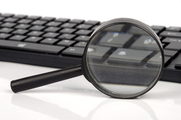 Fototapeta premium Computer keyboard and magnifier