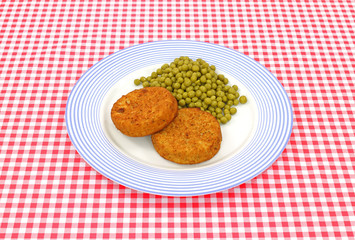 Fish cakes and peas on plate
