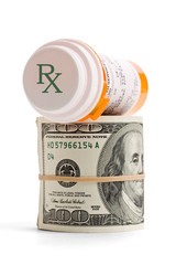Prescription medicine bottle on top of a money roll.