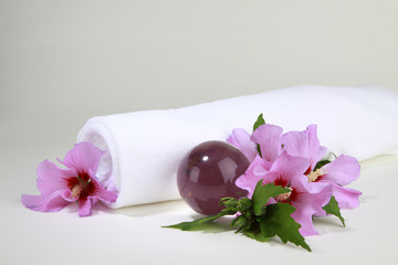 Hibiskusblüten mit weißem Handtuch und Glaskugel