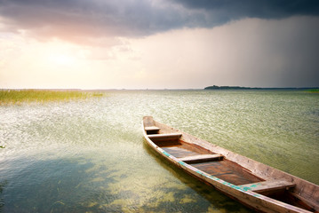 Naklejka na ściany i meble Lonely boat on lake