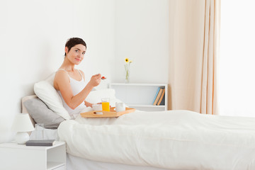 Obraz na płótnie Canvas Good looking woman eating breakfast