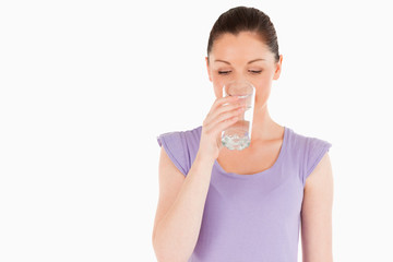 Beautiful woman drinking a glass of water while standing