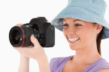 Cute female using a camera while standing