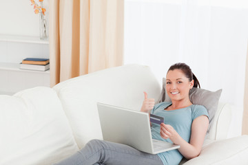 Fototapeta premium Attractive female making an online payment with her credit card
