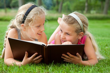 girlfriends reading a book outdoors