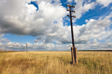 Old wooden electric pillar in the field