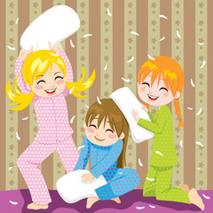 Three young girls having fun in pillow fight