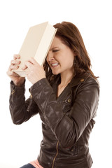 woman slamming book against head