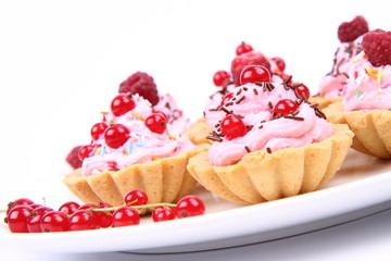 Tartlets with whipped cream, fruits and sprinkles