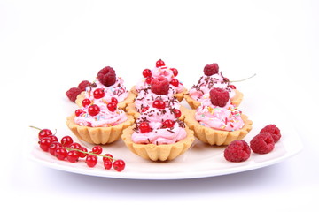 Tartlets with whipped cream, fruits and sprinkles
