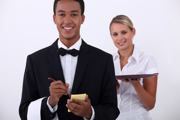 a young latino well dressed waiter writing order