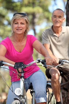 60 years old man and woman doing bike