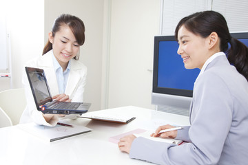 パソコンを使ってプレゼンするOL