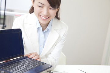 パソコンを使ってプレゼンするOL