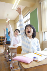 授業中に手を挙げる小学生男女
