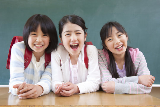 黒板の前で微笑む小学生女子3人