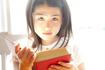図書室で本を読む小学生女子