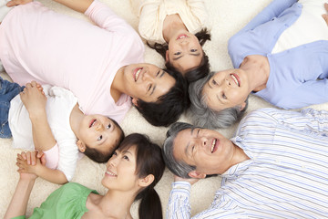 寝転がって微笑む親子3世代