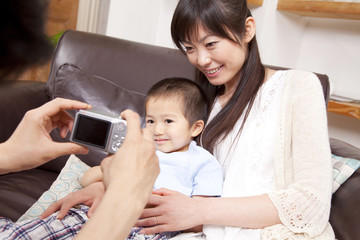 デジカメで家族を撮影する父親